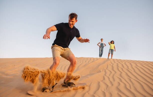 A sandboarder riding down a dune in Timlalin.