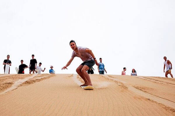 Sandboarding in Marrakech on the golden dunes of Agadir, with a thrilling adventure through Morocco's desert landscapes.